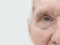 Zbliżenie na niebieskie oko starszego mężczyzny z widocznymi zmarszczkami.