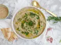 Crema de berenjena asada con aceite de oliva, perejil y semillas de sésamo, servida con pan de pita.