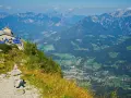 View from Hitler's Eagle's Nest, a stone building with blue umbrellas, perched high in the Bavarian Alps overlooking a valley.