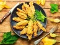 Fiori di zucca in friggitrice ad aria, dorati e croccanti, pronti per essere gustati.