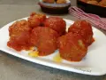 Polpette di pane al sugo, morbide e saporite, servite su un piatto bianco. Un classico della cucina italiana.