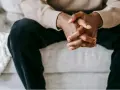 Mains jointes d'un homme, une posture qui peut exprimer le désir, la contemplation ou l'attente.