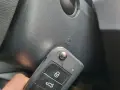 Kluczyk samochodowy z funkcją keyless go w pobliżu przycisku start.