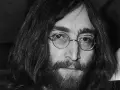 Nahaufnahme von John Lennon III. mit runden Brillengläsern und Bart.