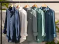 Cinco camisas de lino de colores cuelgan en una percha. El lino, de donde viene el lino, es una fibra natural.