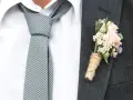 Elegancki krawat do ślubu w kratkę, biała koszula i butonierka z różową różą.