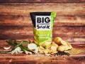 Reklamowa fotografia chipsów Big Snack o smaku zielonej cebulki, z ziemniakami i cebulką.