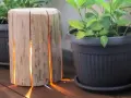 Un tronco di legno con fessure illuminate, un'idea creativa per come costruire una fioriera in legno.