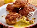 Leckere Frikadellen, goldbraun gebraten, mit Senf auf einem Teller. Ein perfektes Frikadellen Rezept für jeden Anlass.