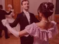 Elegancka para tańczy walc angielski na balu. Ona w pastelowej sukni, on w fraku.