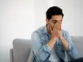 Hombre con las manos en la cara, ojos cerrados, sintiendo que la nicotina marea.