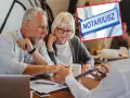Starsze małżeństwo u notariusza omawia, ile kosztuje przepisanie mieszkania. Tabliczka "NOTARIUSZ" potwierdza miejsce.