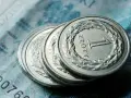 Monety 1 złoty leżące na banknocie.
