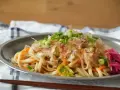Udon z warzywami i szczypiorkiem, posypany płatkami katsuobushi. To właśnie katsuobushi co to jest, suszone płatki bonito, dodają daniu głębi smaku.