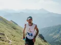 Zawodnik z numerem 111 biegnie pod górę podczas Tatra Sky Marathon. W tle piękne, mgliste pasmo górskie.