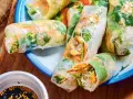 Rouleaux de printemps frais et colorés, parfaits pour une recette facile. On y voit des vermicelles de riz, des légumes croquants et des cacahuètes.