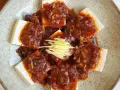 Tofu comida servida en un plato con salsa picante y jengibre rallado.