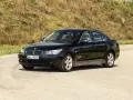 Czarne BMW 535d na tle zielonego wzgórza.
