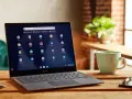Laptop z systemem Chrome OS Flex na drewnianym stole, obok kubek i klucze.