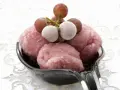 Erfrischendes Traubeneis auf einem Löffel, garniert mit gefrorenen Trauben. Ein süßer Genuss!