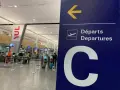 Tablica kierująca na lotnisku Montreal YUL, z napisem "Departures" i dużą literą "C".