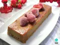 Delicioso pudin de pan casero, cubierto con fresas congeladas y un glaseado dorado.