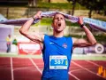 Atleta exhausto, con la boca abierta y una toalla sobre la cabeza, celebra el fin de correr una maratón.