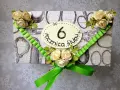Elegancka kartka z ozdobami kwiatowymi i zieloną wstążką, z napisem "6 rocznica ślubu".