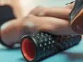 Un rullo massaggiante texturizzato aiuta a capire come si usa il rullo massaggiante per il recupero muscolare.
