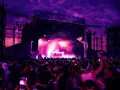Tłum na festiwalu tańca pod fioletowym niebem. Na scenie DJ, dym i światła. To musi być świetny green festival program!