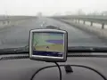 Nawigacja TomTom na desce rozdzielczej samochodu podczas jazdy w mglisty dzień.