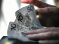 Dłonie trzymają polskie banknoty 10 i 50 zł. Czy na bierzmowanie daje się prezenty? Pieniądze mogą być odpowiedzią.