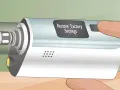 Mano ajustando un vapeador sin atomizador. La pantalla muestra "Restaurar configuración de fábrica".