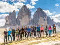 Grupa przyjaciół na tle Tre Cime di Lavaredo podczas niezapomnianego trekkingu w Dolomitach.