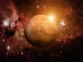 El planeta Marte brilla en el cosmos, rodeado de nebulosas y estrellas. Su superficie rojiza evoca la energía de una marte carta astral, guiando destinos.