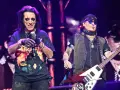 Alice Cooper i Johnny Depp, członkowie Hollywood Vampires, na scenie. Cooper śpiewa, Depp gra na gitarze.