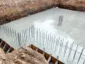 Świeżo wylany beton na budowie, zbrojenie fundamentów gotowe do dalszych prac. Ocieplenie fundamentów będzie kolejnym etapem.