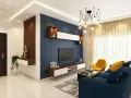 Salones con papel pintado azul rayado, un sofá azul, sillón amarillo y mesa de centro.