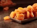 Getrocknete Aprikosen in einer Holzschale, ein gesunder Snack voller Vitamine.