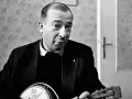 Jerzy Putrament, z gitarą w dłoniach, jakby inspirowany do tworzenia nowych utworów.