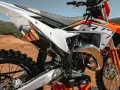 Dettaglio di una moto da cross KTM con scarico FMF. Il suo motore 4 tempi è pronto per la pista.