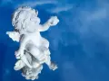 Biały cherubin na tle błękitnego nieba, odbijający się w lustrzanej powierzchni. Symbolizuje różne rodzaje modlitwy, od błagania po dziękczynienie.
