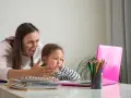 Zła kobieta krzyczy na dziecko przy laptopie.