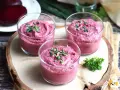 Tre bicchierini di crema di barbabietola, perfetti antipasti veloci senza cottura, guarniti con erba cipollina.