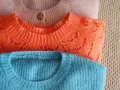 Gestapelte Pullover in Rosa, Orange und Blau. Zeit für die **Wolle waschen**, damit sie wieder flauschig sind.