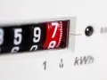 Zbliżenie na licznik przedpłatowy pokazujący 8597 kWh. Cyfry na obrotowych bębenkach, jeden z nich czerwony.