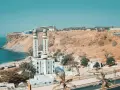 Wspaniały widok na meczet z dwoma minaretami nad oceanem, w kraju z Dakarem. W oddali klif i budynki.