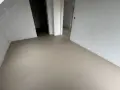 Nowe, gładkie podłogi z **mikrobetonu** w stanie surowym, gotowe na dalsze prace wykończeniowe.