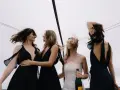 Sorelle della sposa, con abiti neri eleganti, celebrano il matrimonio con champagne. Accessori per abito nero matrimonio perfetti per un look sofisticato.