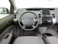 Wnętrze Toyoty Prius 2 z kierownicą, panelem radia i ekranem.